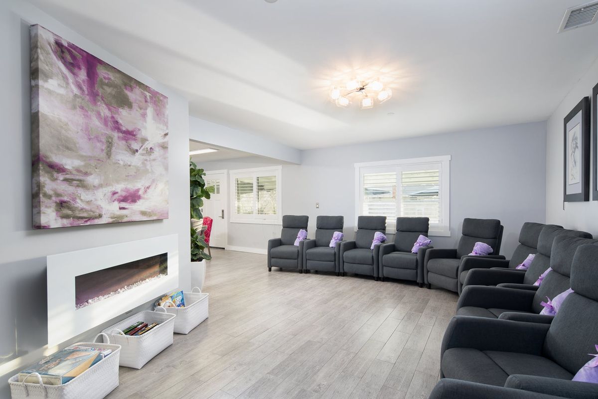 A modern waiting room with comfortable recliner chairs and contemporary artwork.