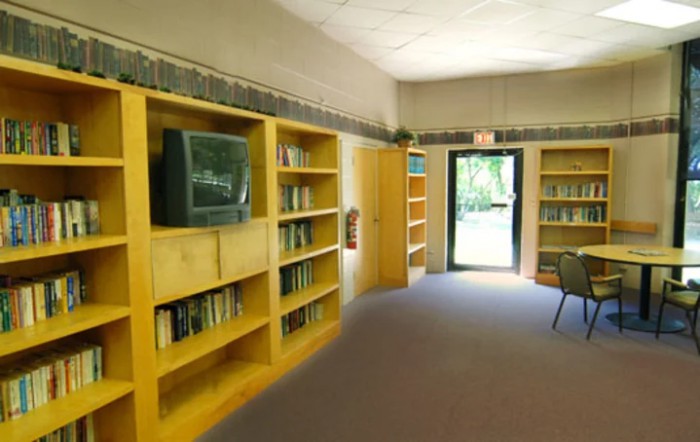 A library interior with bookshelves and a television by the door.