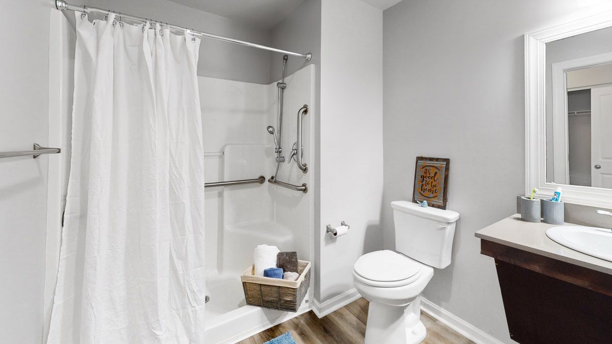 A modern bathroom with a bathtub, shower curtain, and toilet.