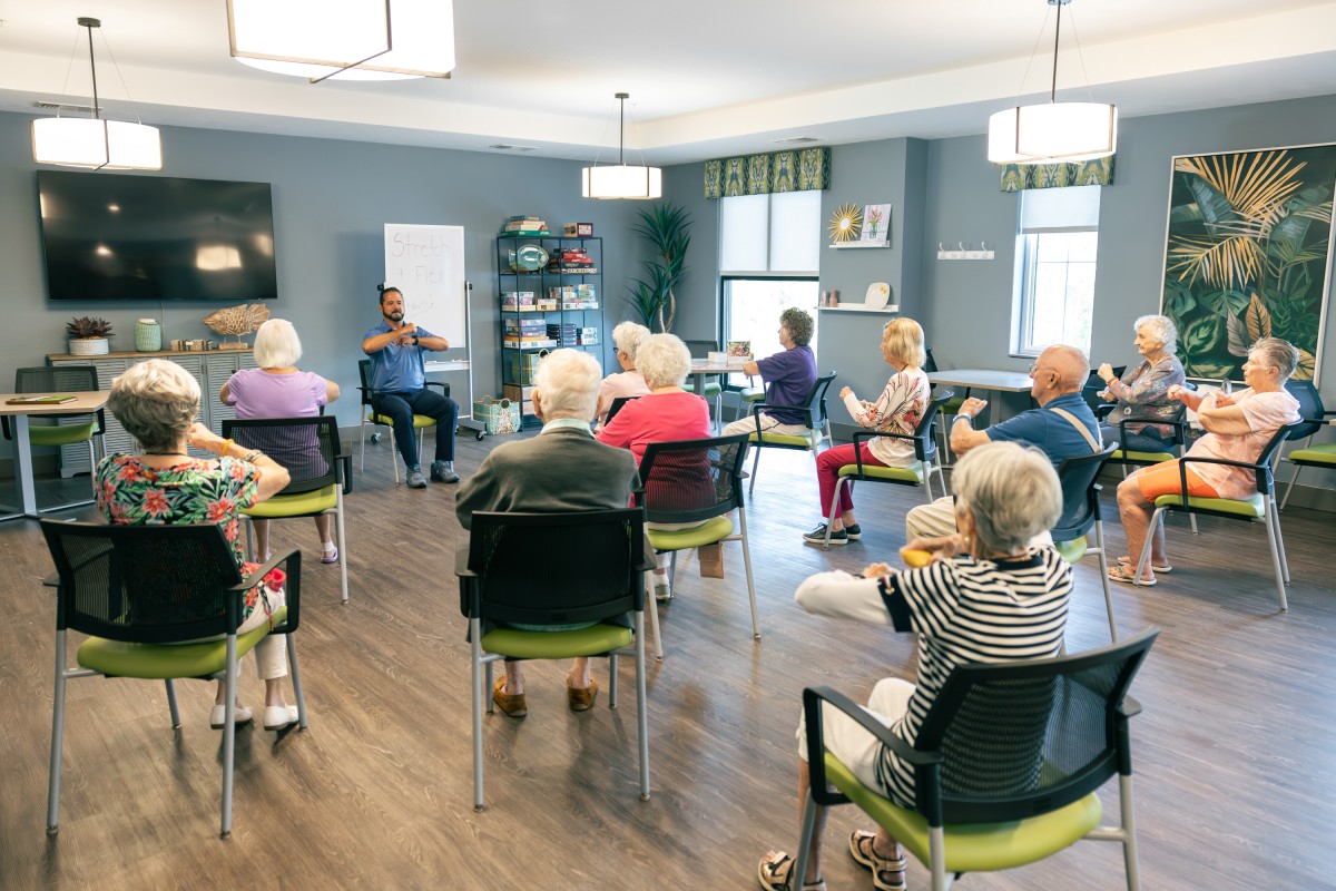 A group of seniors attending a community meeting indoors.
