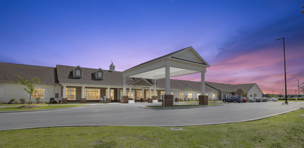 A modern building with a covered entrance at sunset.