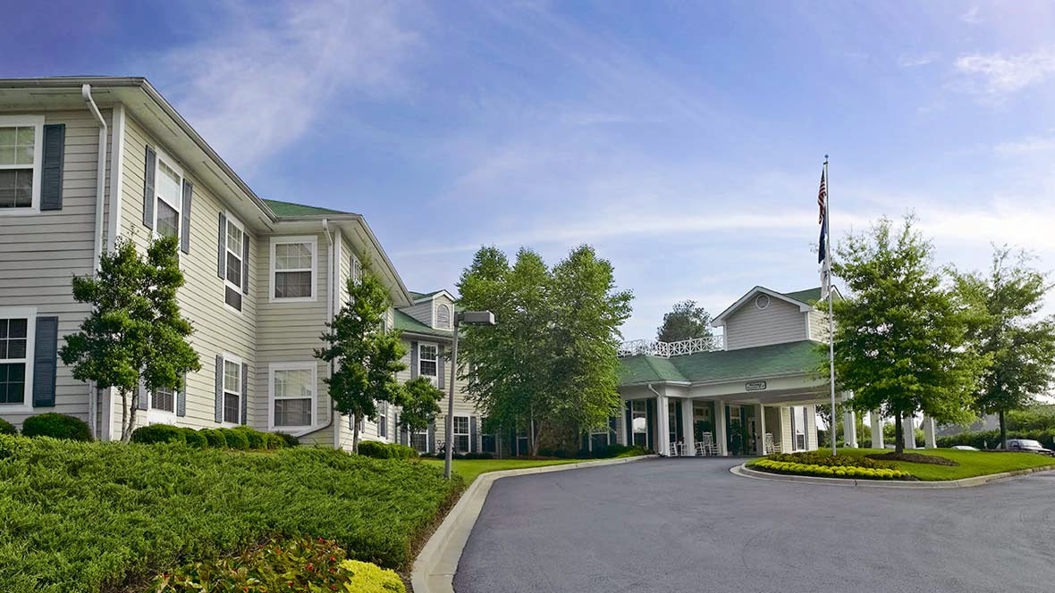 A well-maintained residential building with landscaped surroundings and a driveway.