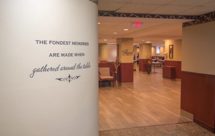 A cozy restaurant interior with a welcoming quote on the wall.