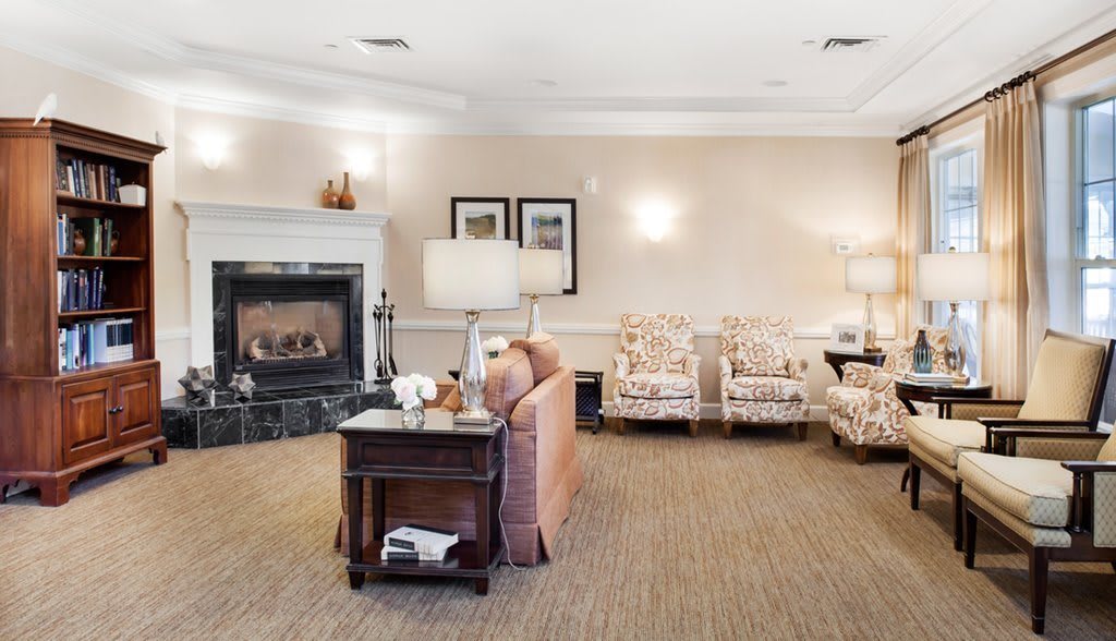 A cozy living room with a sofa, armchairs, and a fireplace.