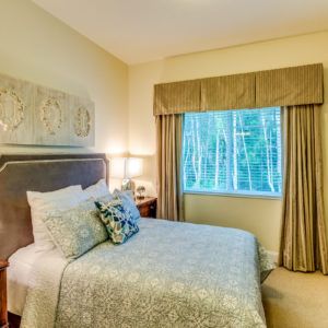 A cozy and well-decorated bedroom with a large window.