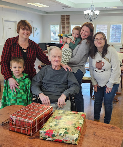 A joyful family gathering celebrating together with gifts and smiles.