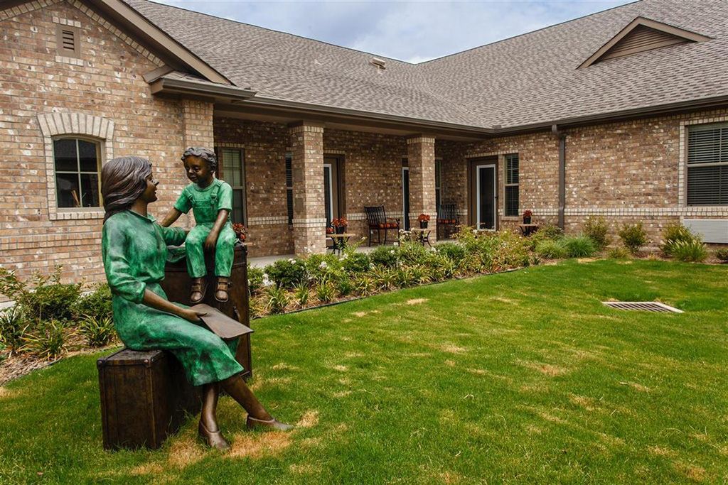 A serene garden with sculptures outside a brick building.