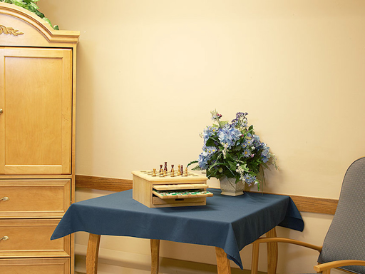 A cozy setup featuring a chess set and a floral arrangement on a blue table.