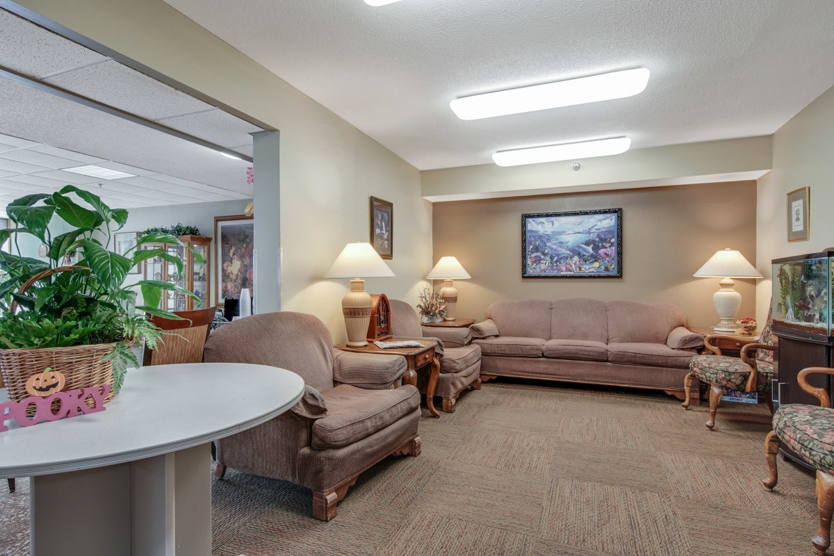 A cozy living room with comfortable sofas, lamps, and artwork on the wall.