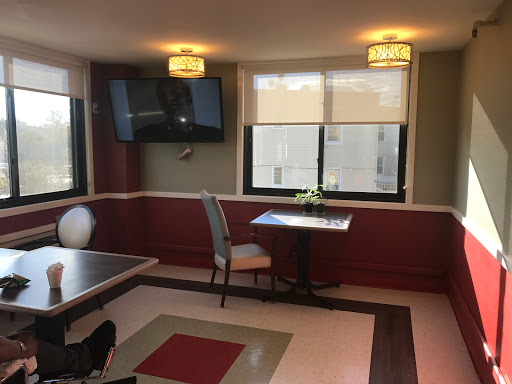A cozy dining area featuring a small table, a chair, and a television mounted on the wall.