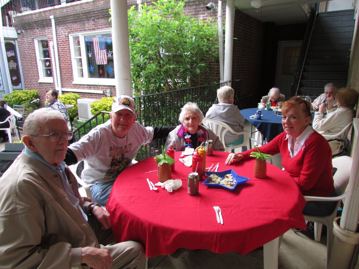 A group of people enjoying a meal together at an outdoor restaurant table.