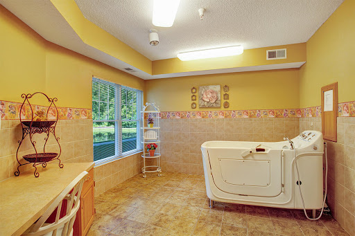 A spacious bathroom featuring a comfortable tub and serene yellow hues.