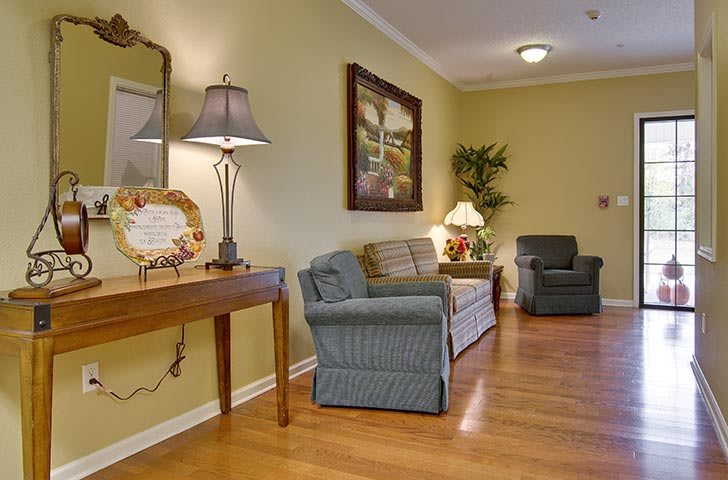 A cozy living room with a sofa, chairs, and warm lighting.