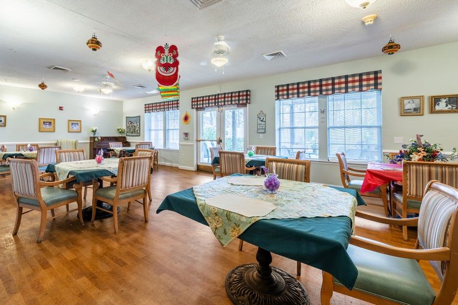 A well-lit dining area with tables and chairs, adorned with colorful decorations.