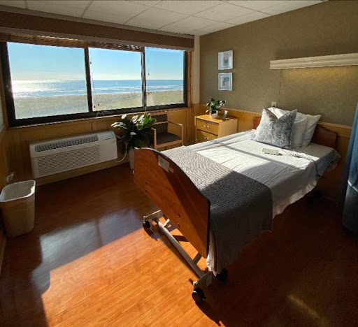 A serene hospital patient room featuring a bed with a view of the ocean.