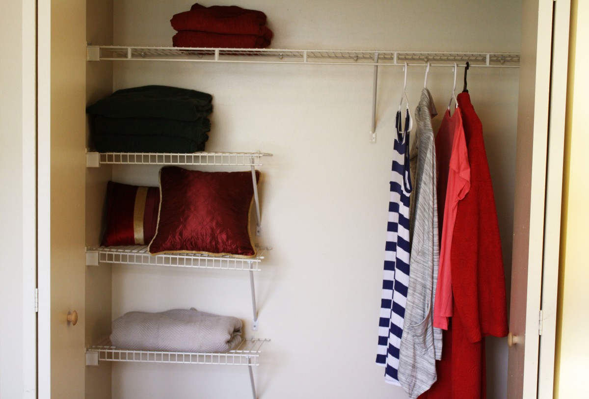 Organized closet with hanging clothes and neatly arranged shelves.