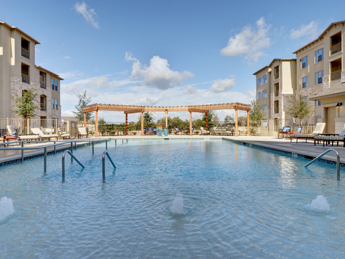 A serene view of an outdoor swimming pool surrounded by residential apartment buildings.