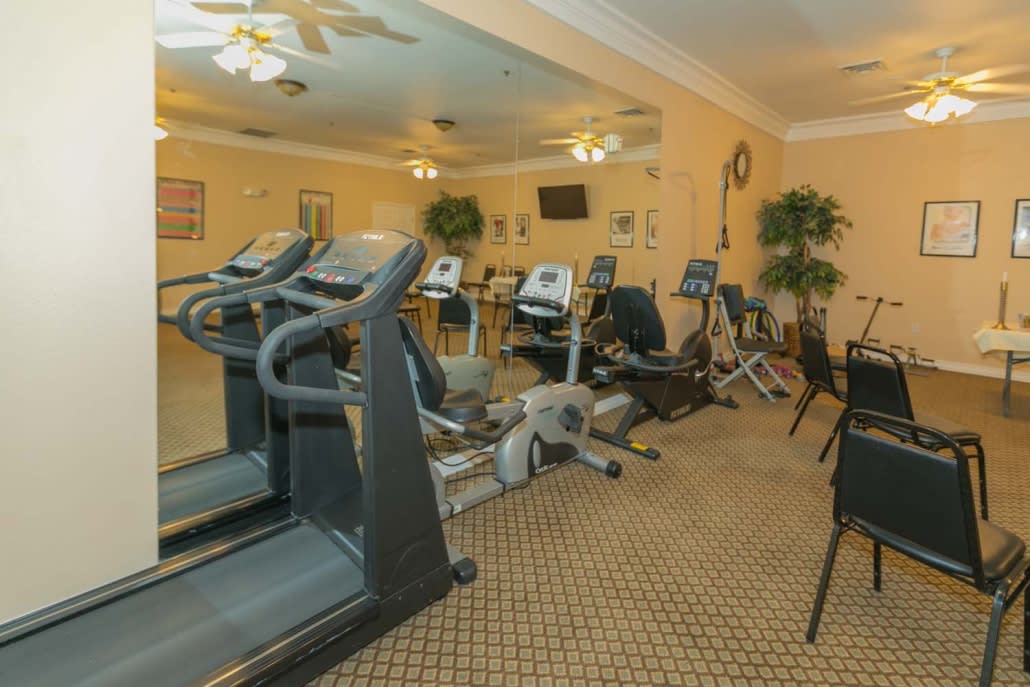 A well-equipped gym with treadmills and exercise bikes in a spacious indoor setting.