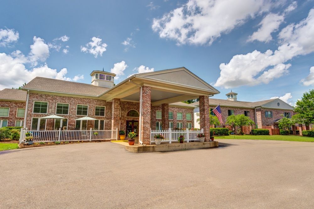 Exterior view of a hotel entrance with a covered driveway and brick facade.