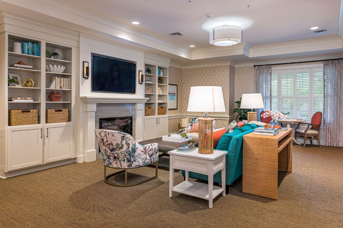 A cozy and well-decorated living room featuring a comfortable sofa, a fireplace, and a mounted television.