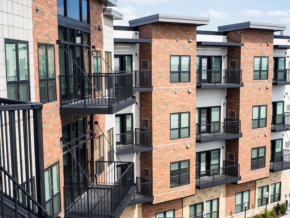 A modern apartment building with brick exterior and balconies.