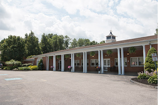 A view of a brick building with pillars, set against a cloudy sky.