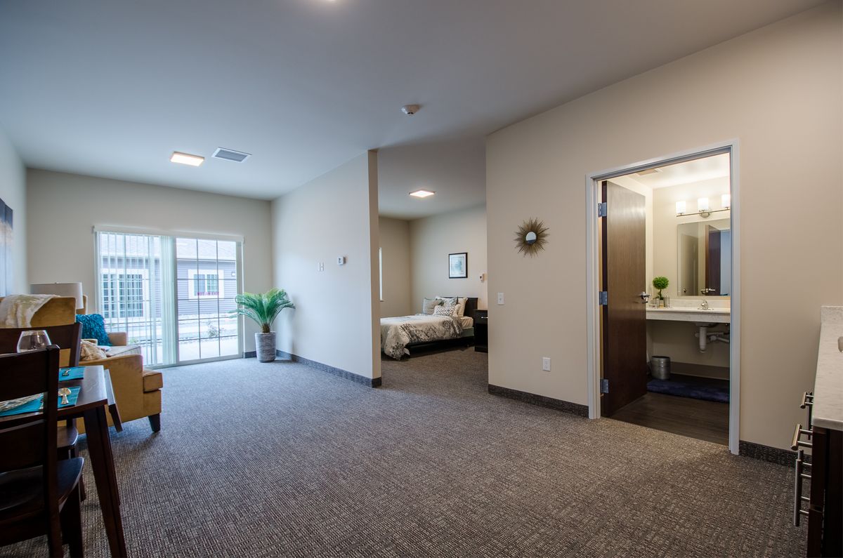 A modern interior space featuring a bedroom and a living area with ample natural light from large windows.