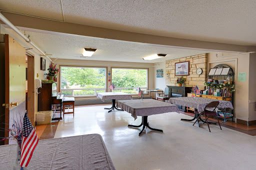 A spacious dining area with tables set for guests, bathed in natural light from large windows.