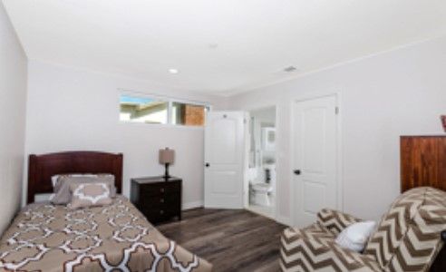 A cozy bedroom with a bed, nightstand, and a view into an adjoining bathroom.