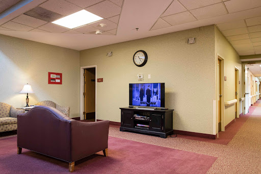 A cozy living room setup featuring a television, a comfortable sofa, and a wall clock.