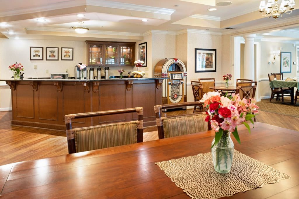 Cozy dining area with a bar and floral centerpiece.