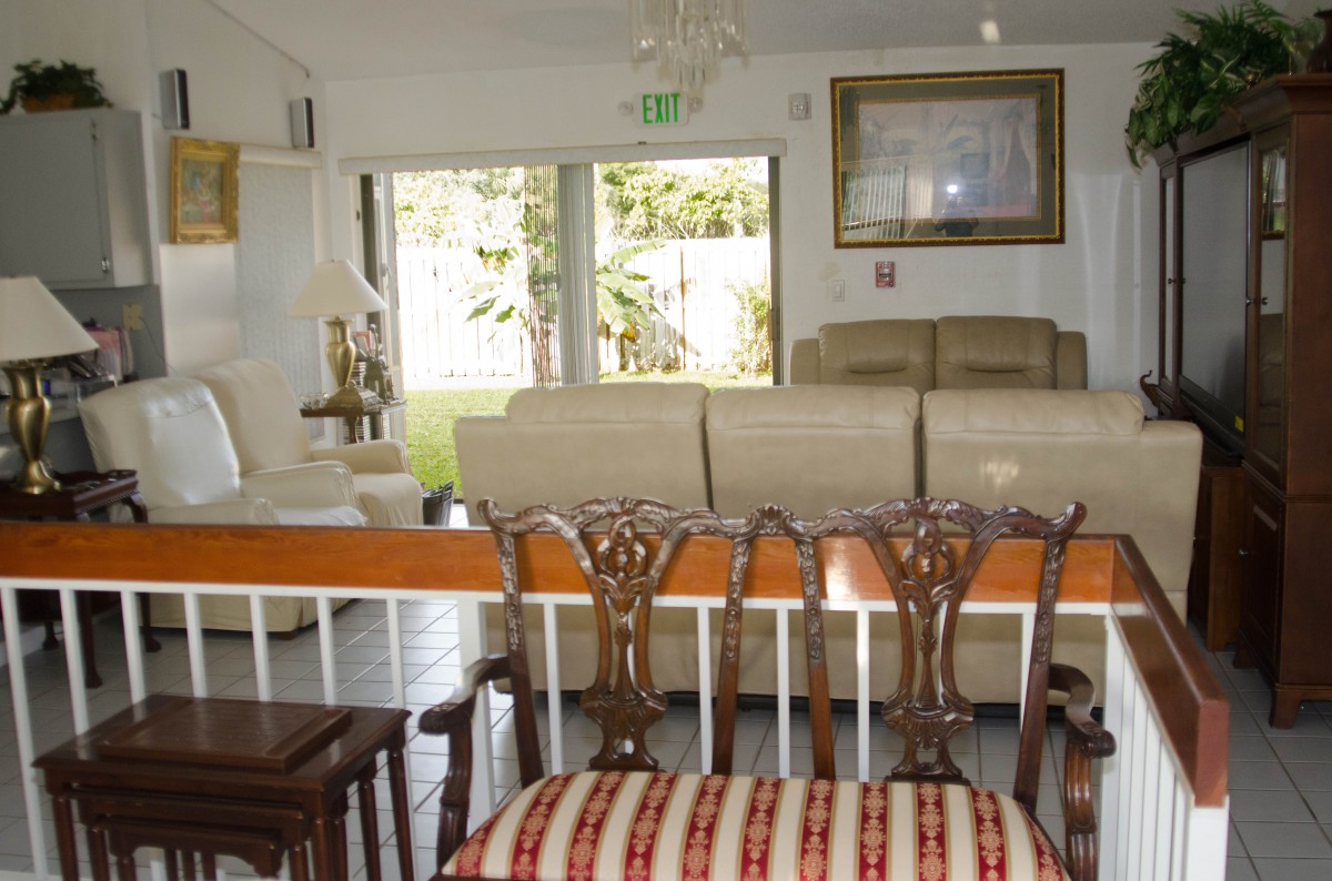 A cozy living room with a variety of seating options including chairs and a couch near large windows.