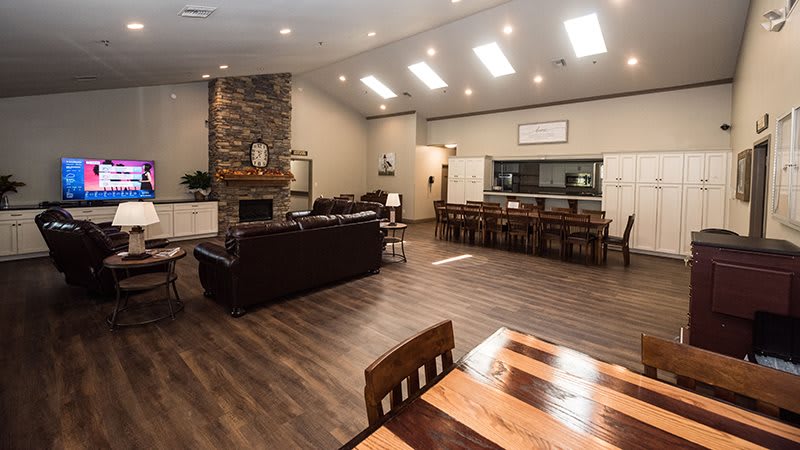A spacious and modern living room with a fireplace, hardwood floors, and an open dining area.