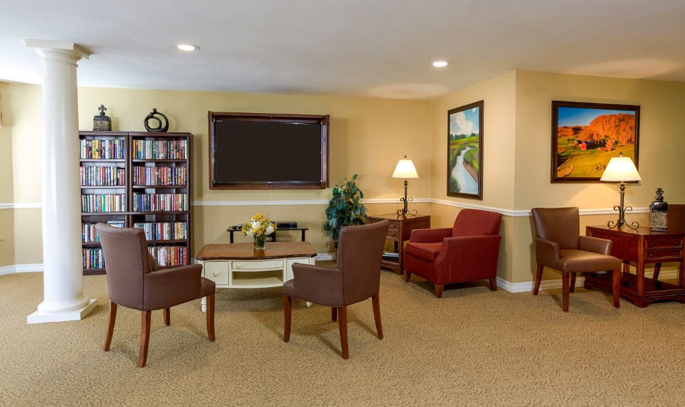 A cozy living room with comfortable seating, a bookshelf, and a television.