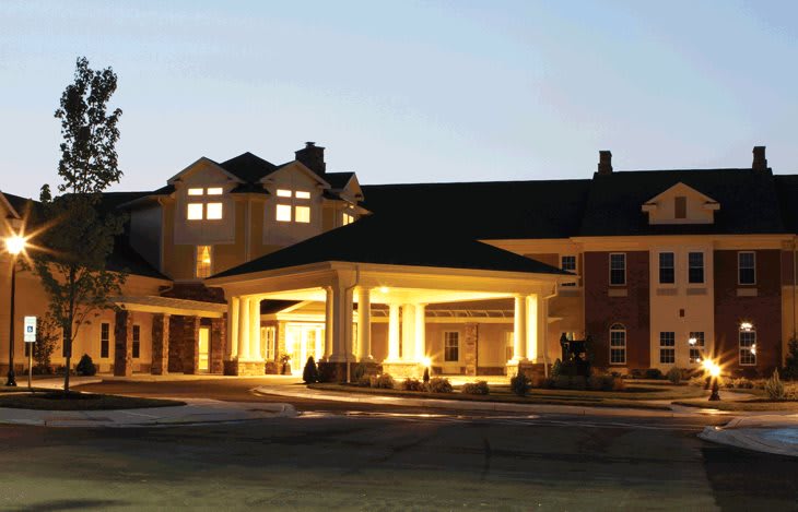 A warmly lit building entrance at dusk.