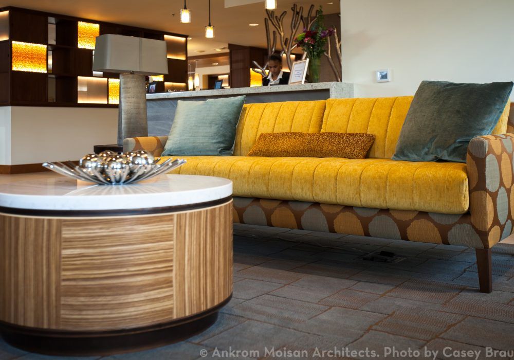 A modern living room featuring a yellow sofa and a stylish wooden coffee table.