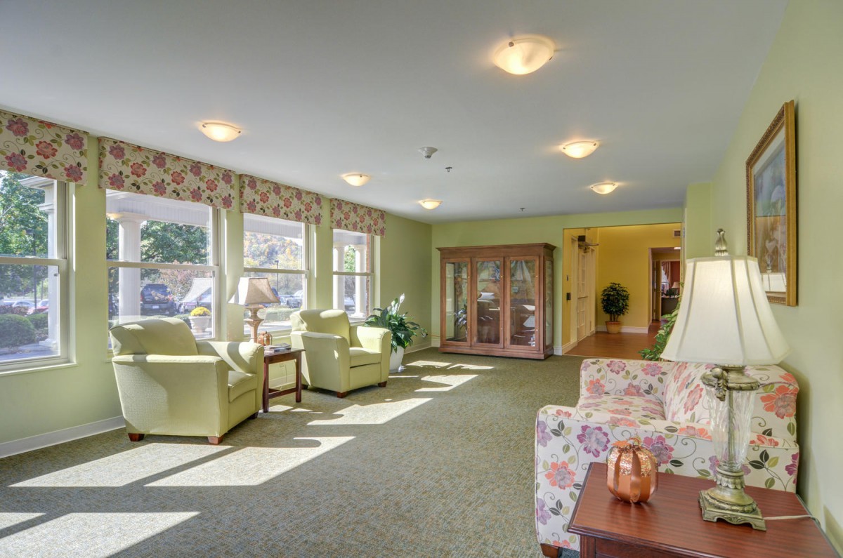 A cozy living room with comfortable seating and ample natural sunlight streaming through large windows.