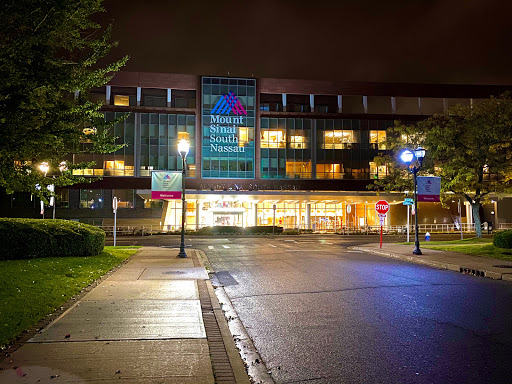A modern building illuminated at night, showcasing its contemporary design in an urban setting.