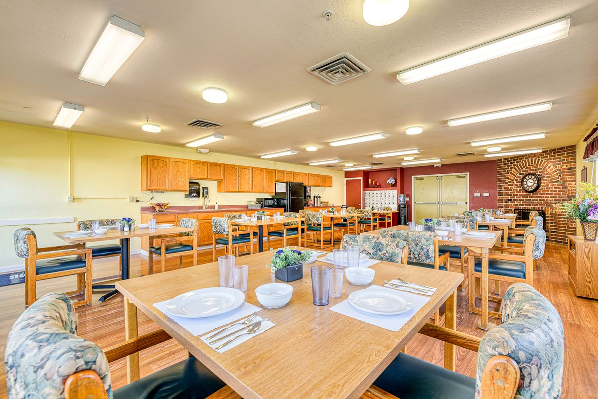 A brightly lit dining area with neatly arranged tables and chairs, ready for guests.
