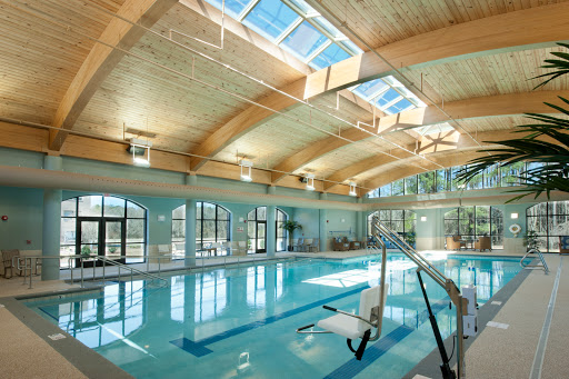 A serene indoor swimming pool featuring large skylights and a wooden ceiling, perfect for relaxation and recreation.