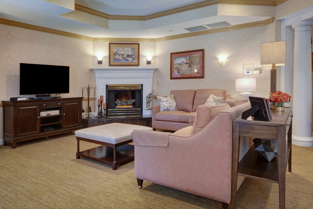 A cozy living room with a fireplace, sofas, and tasteful artwork.