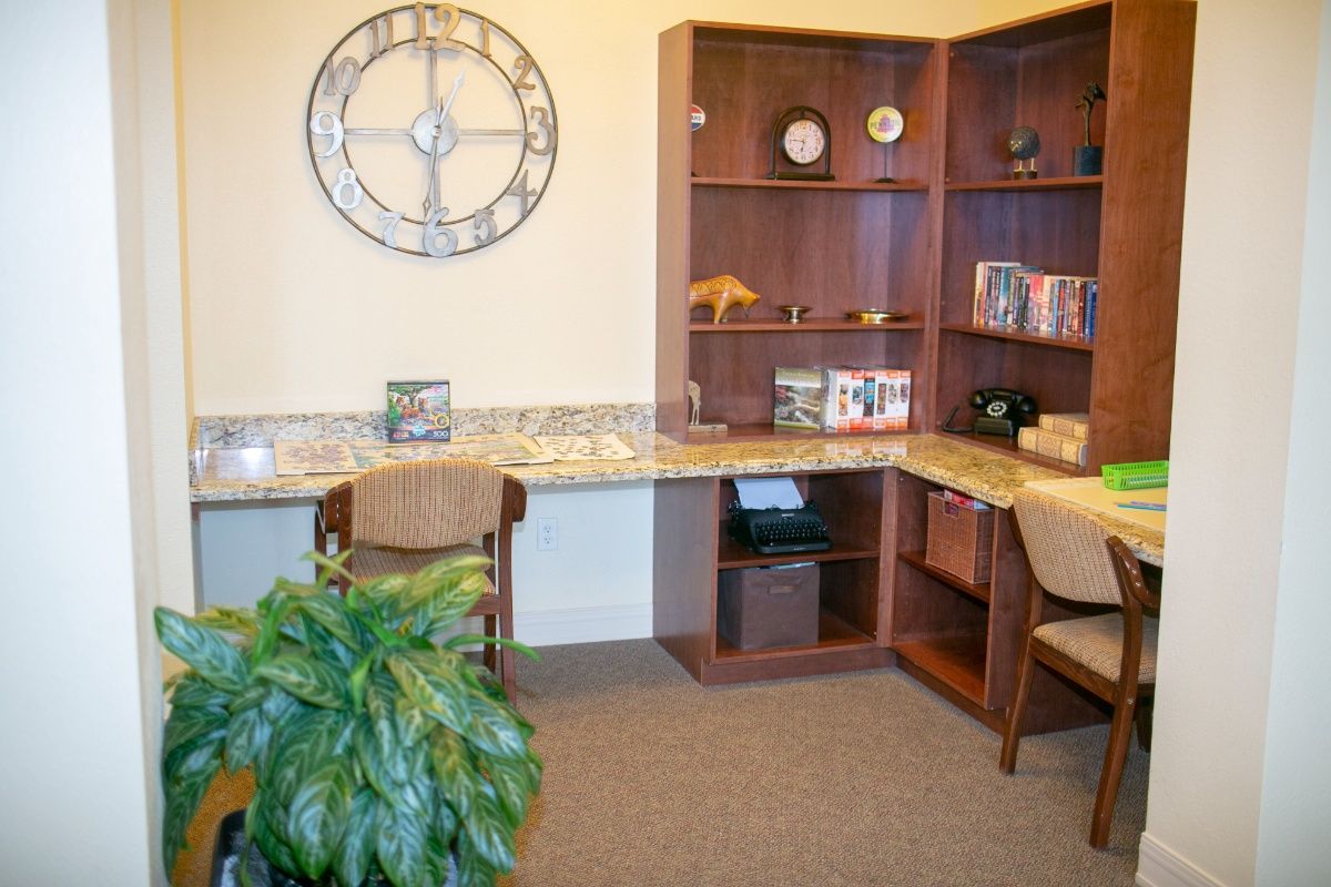 A cozy office space with wooden shelves, a desk, and decorative items.