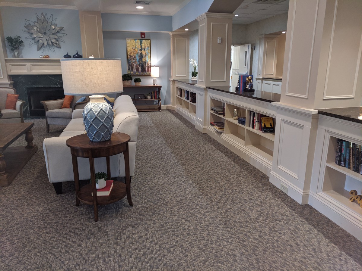 A cozy living room with a sofa, lamp, and built-in bookshelves.