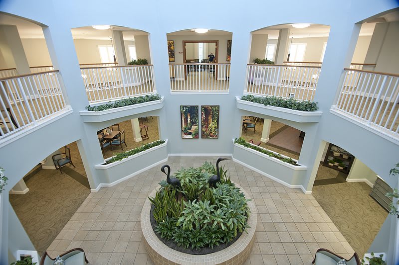 A spacious atrium with indoor greenery and surrounding balconies.