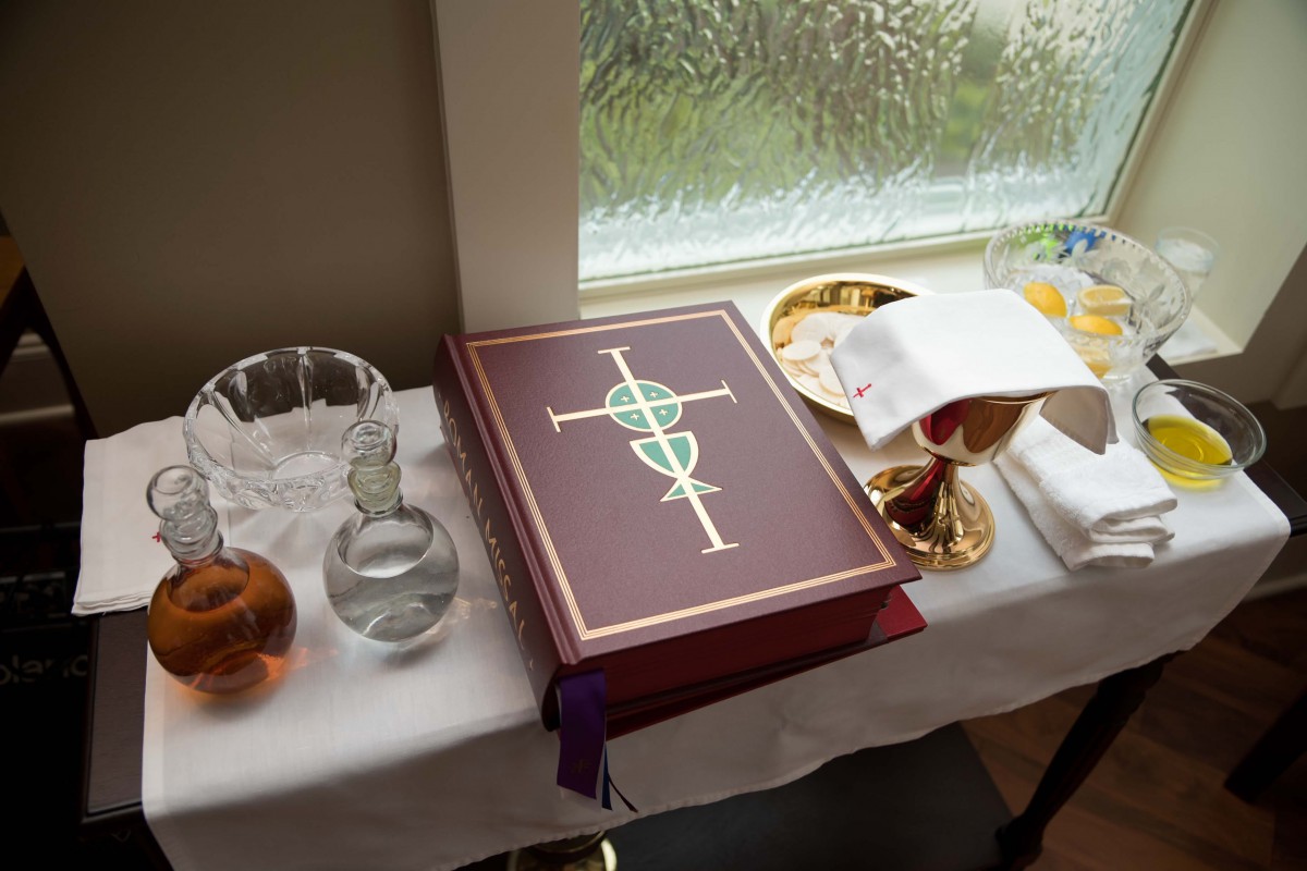An altar setup with a Bible, chalice, and communion items.