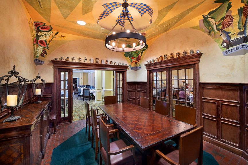 A beautifully designed dining or conference room featuring a large wooden table, traditional decor, and an ornate chandelier.