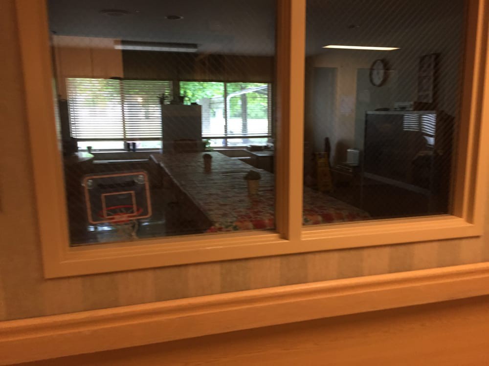 View through a window into a room with furniture and decoration.