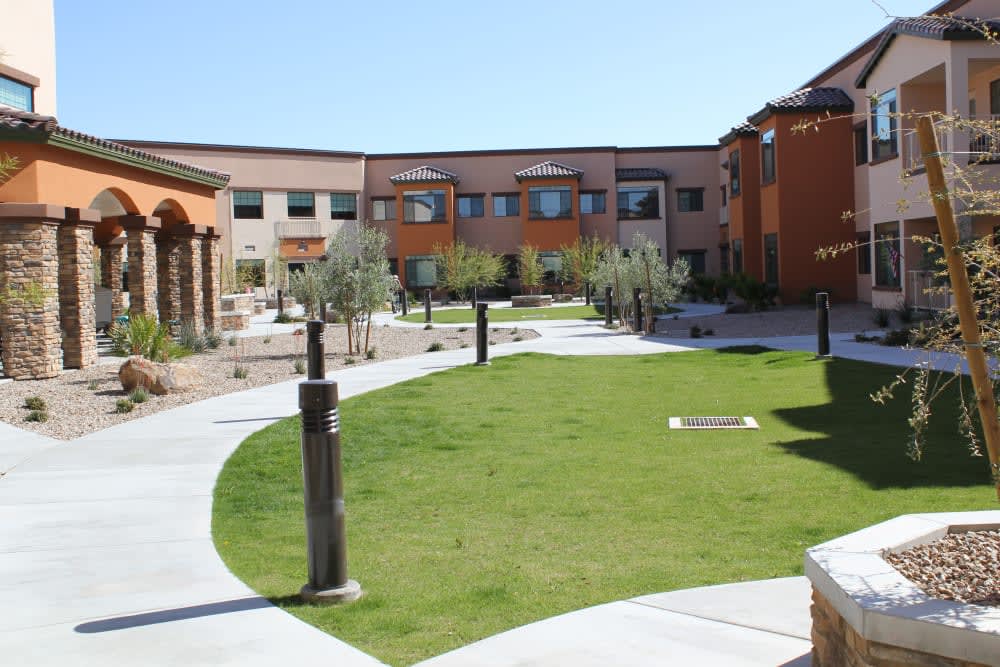 A modern courtyard with landscaped greenery and surrounding buildings.