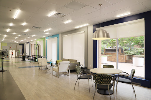 A modern lounge area featuring comfortable seating and plenty of natural light.