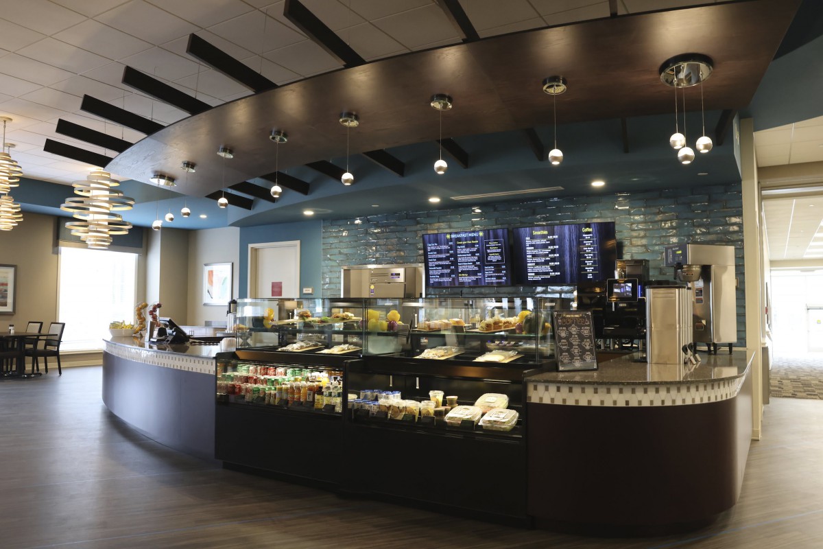 Modern cafe interior with a display counter and menu boards.